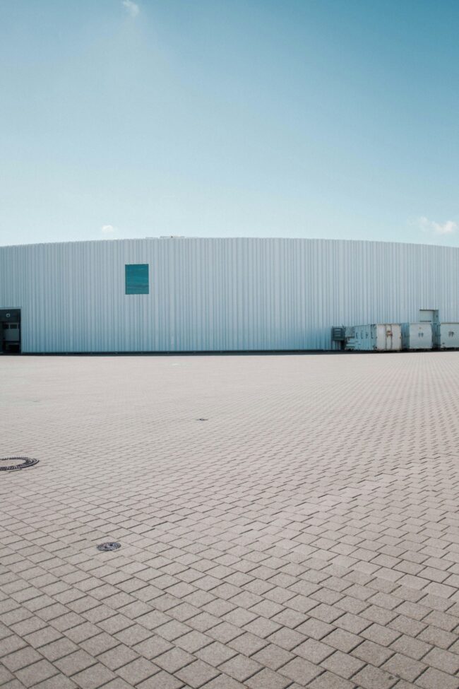 a large warehouse building with a blue sky in the a large warehouse building with a blue sky in the background