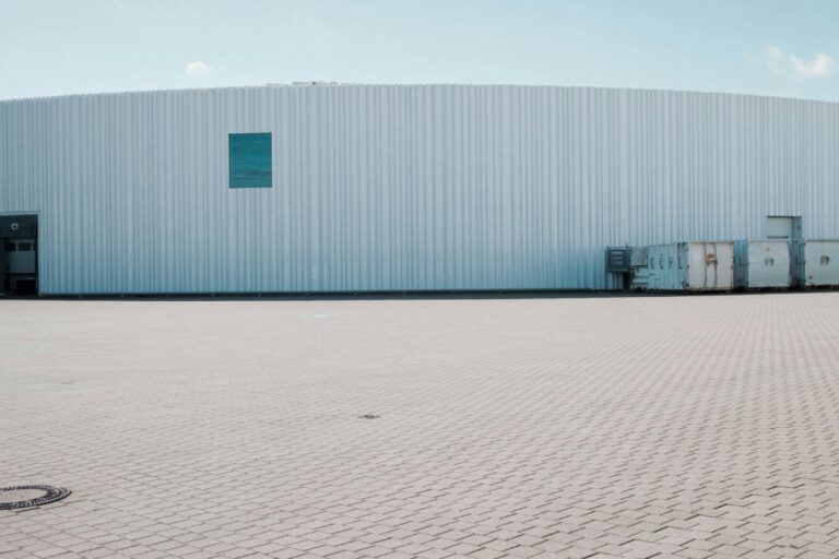 a large warehouse building with a blue sky in the background