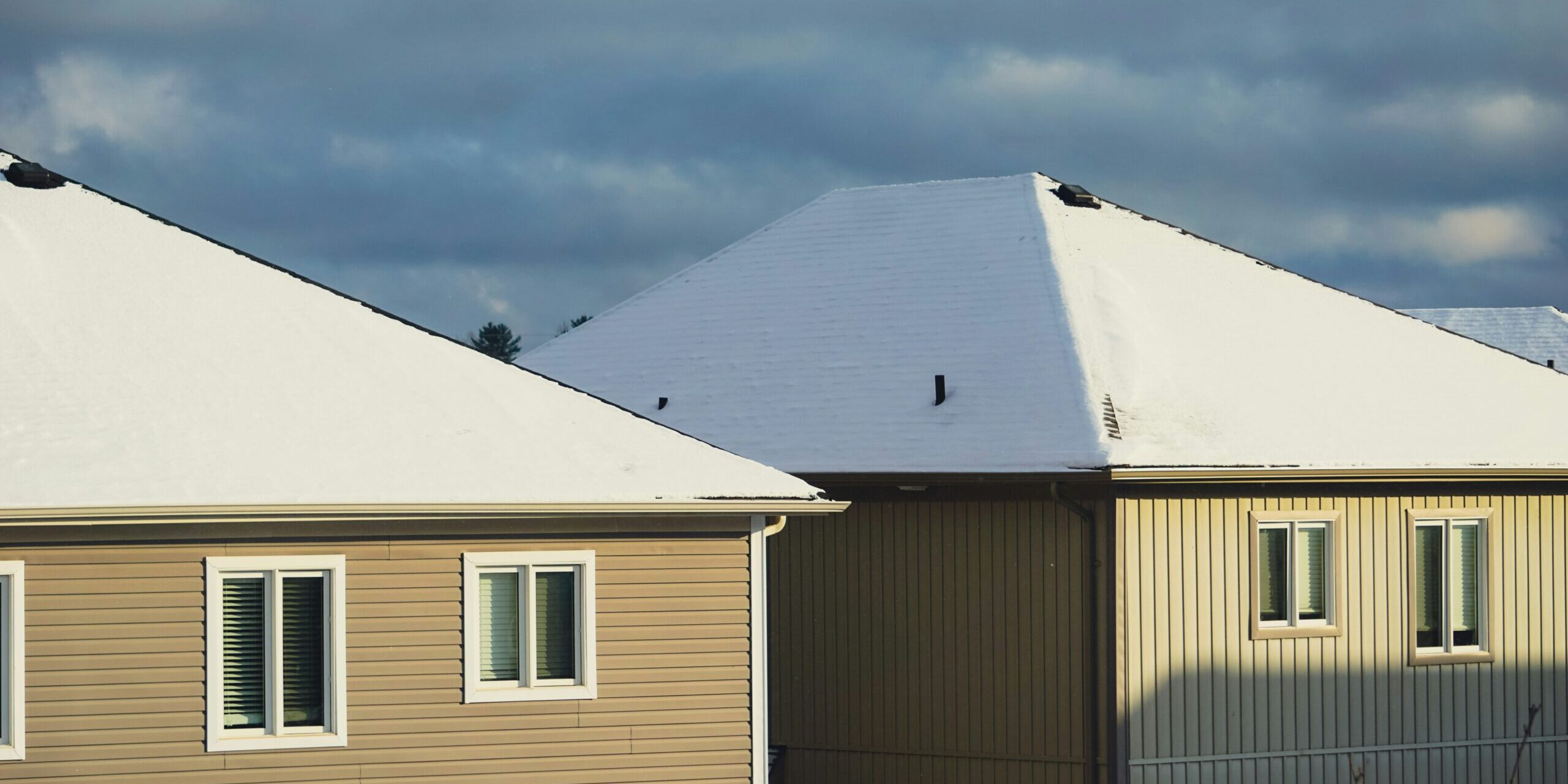 a row of houses with snow on top of them a row of houses with snow on top of them