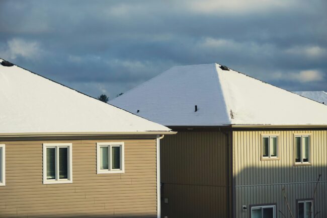 a row of houses with snow on top of them a row of houses with snow on top of them