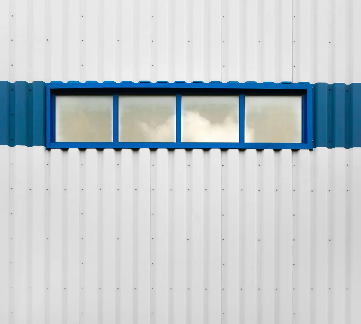 a white building with a blue window on the side of it