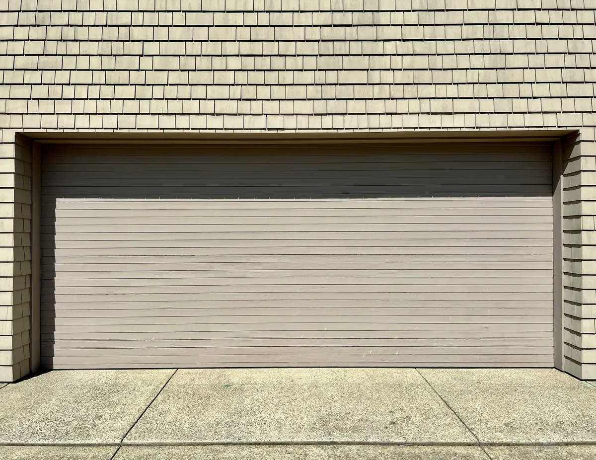 a white fire hydrant sitting in front of a garage door