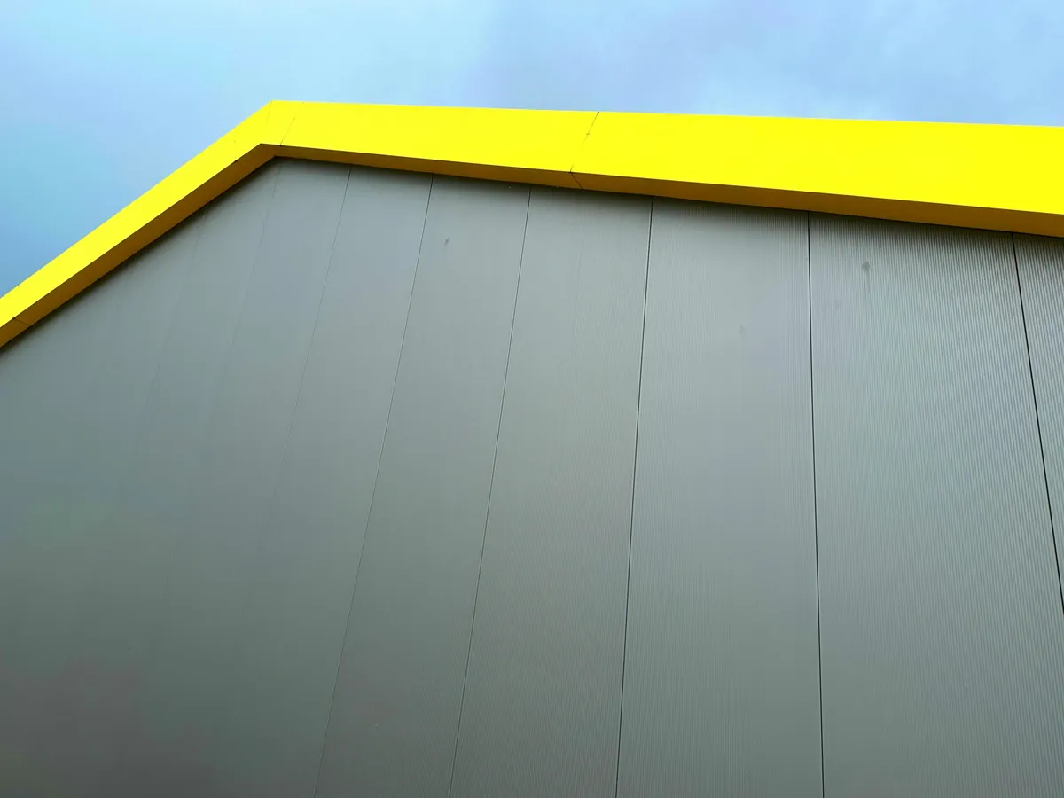 a yellow and gray building with a clock on the side