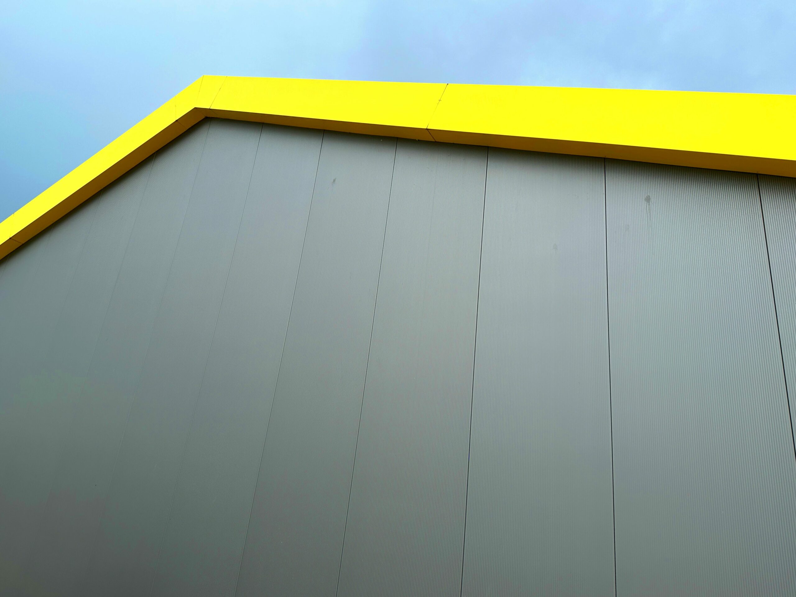 a yellow and gray building with a clock on the side