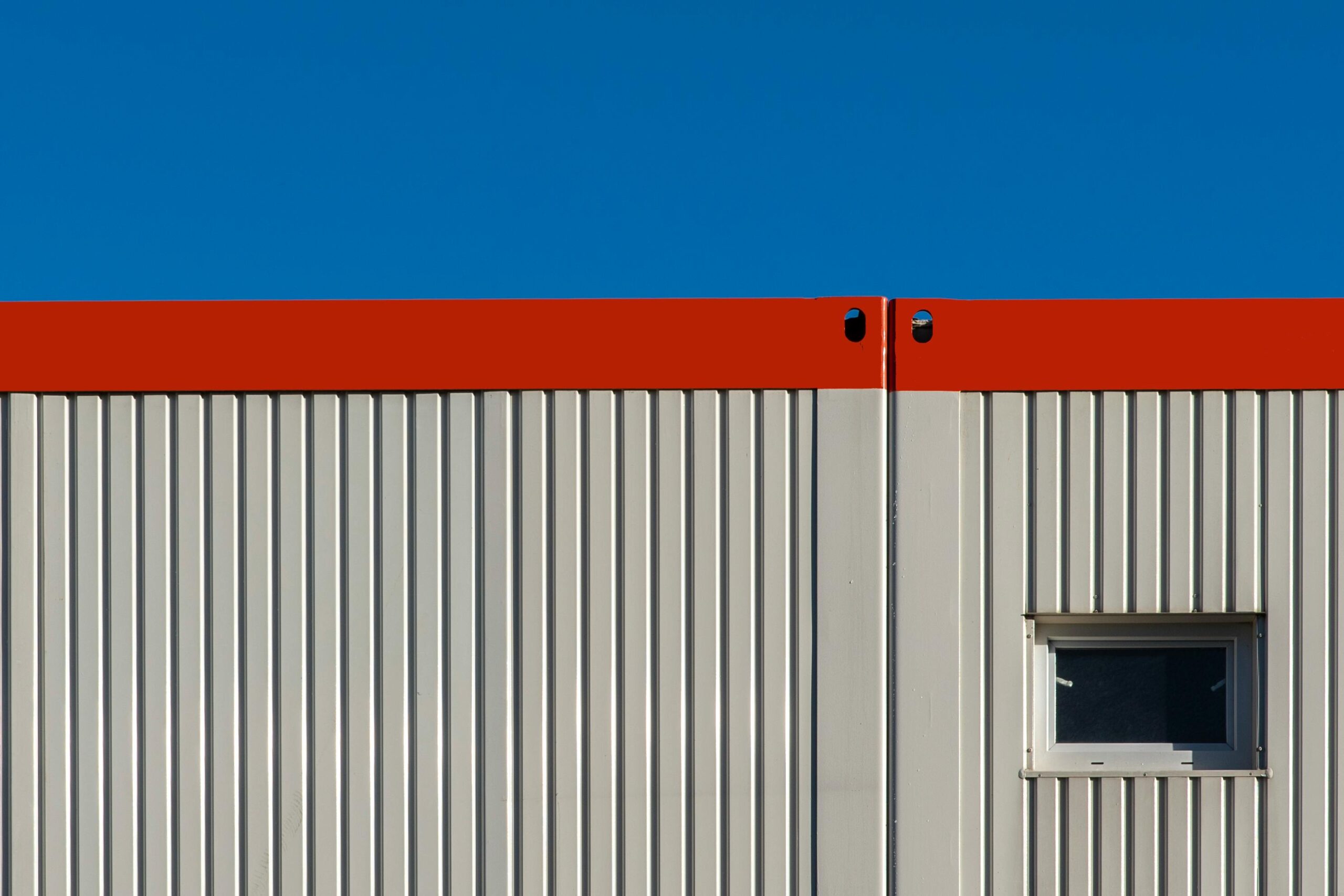 Bright minimalist photo of industrial building facade with contrasting colors and modern design element.