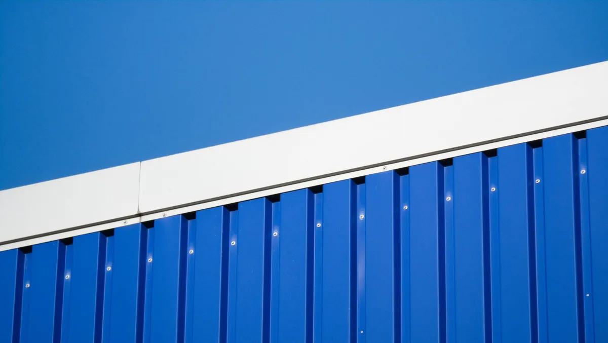 Close-up of a blue metal industrial wall against a clear sky in Hamburg.