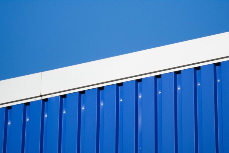 Close-up of a blue metal industrial wall against a clear sky in Hamburg.