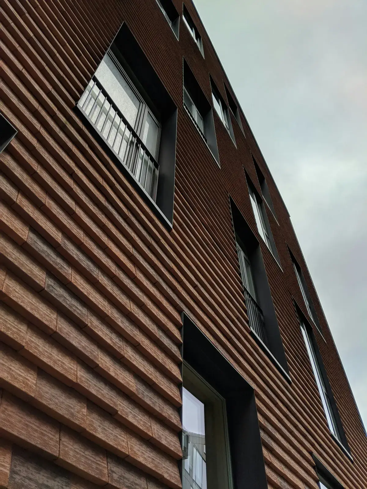 Facade installation team securing aluminum composite sandwich panels with floating fastener clips (Source: Commercial Construction Manual)
