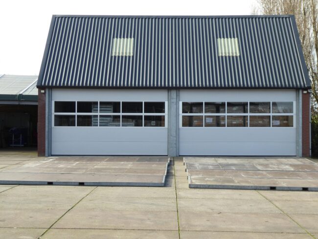 Front view of a modern warehouse building with cor Front view of a modern warehouse building with corrugated roofing and skylights.