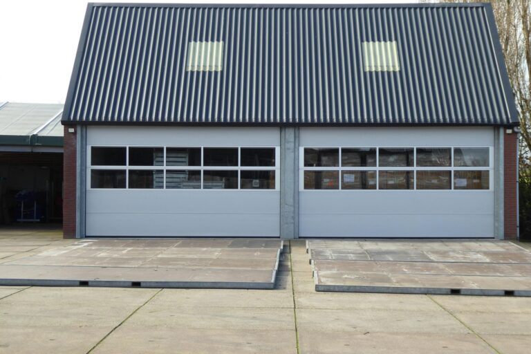 Front view of a modern warehouse building with corrugated roofing and skylights.