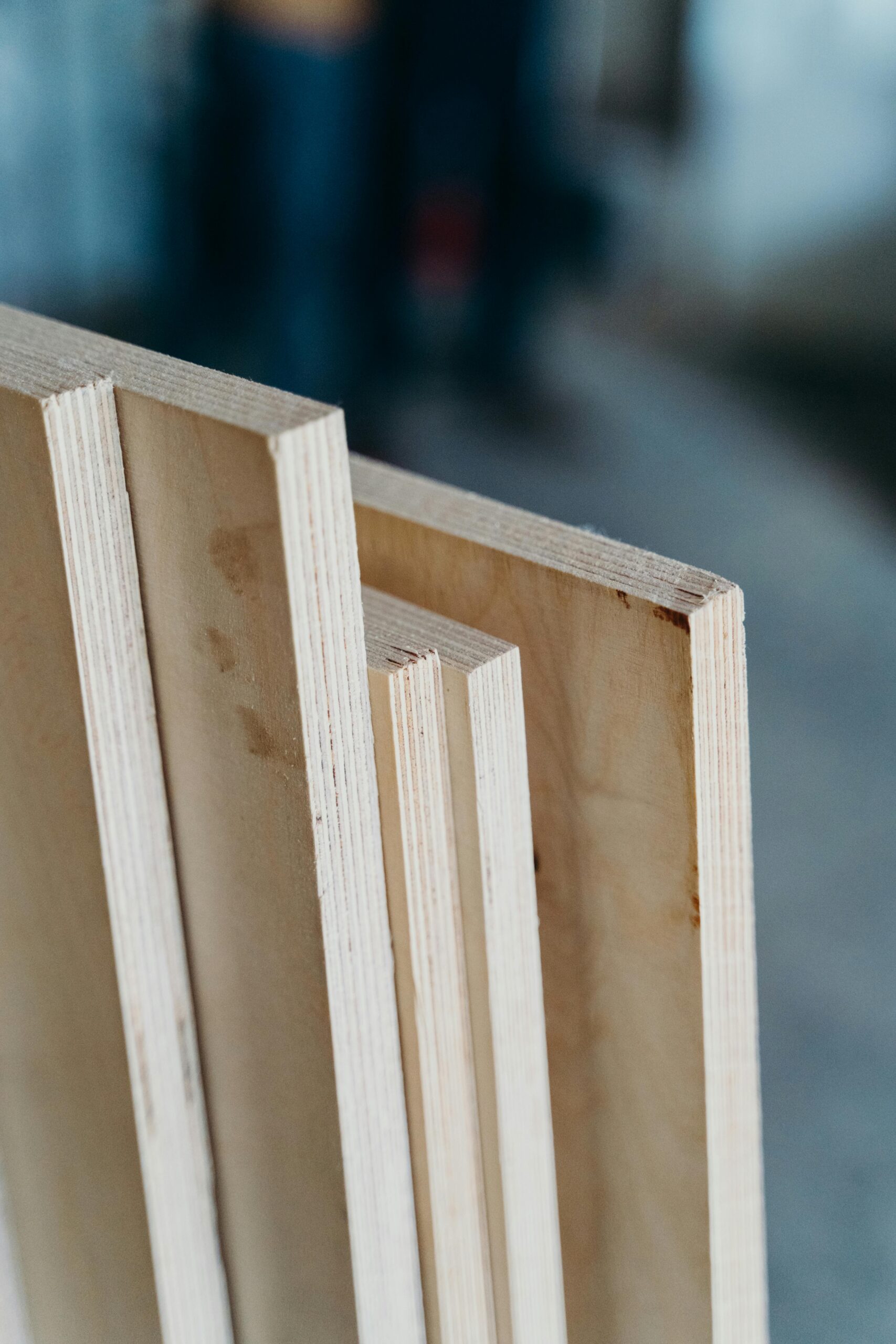 Hyper-realistic, conceptual photograph set in a clean, modern warehouse. Three neat stacks of honeycomb panels are arranged in a row. The first stack is the shortest and made of low-density panels (large cells). The middle stack is taller and made of medium-density panels. The third stack is the tallest, made of high-density panels (small cells), visually representing the correlation between density and cost. Bright, even lighting, minimalist composition, financial concept, no text, no brand logo.