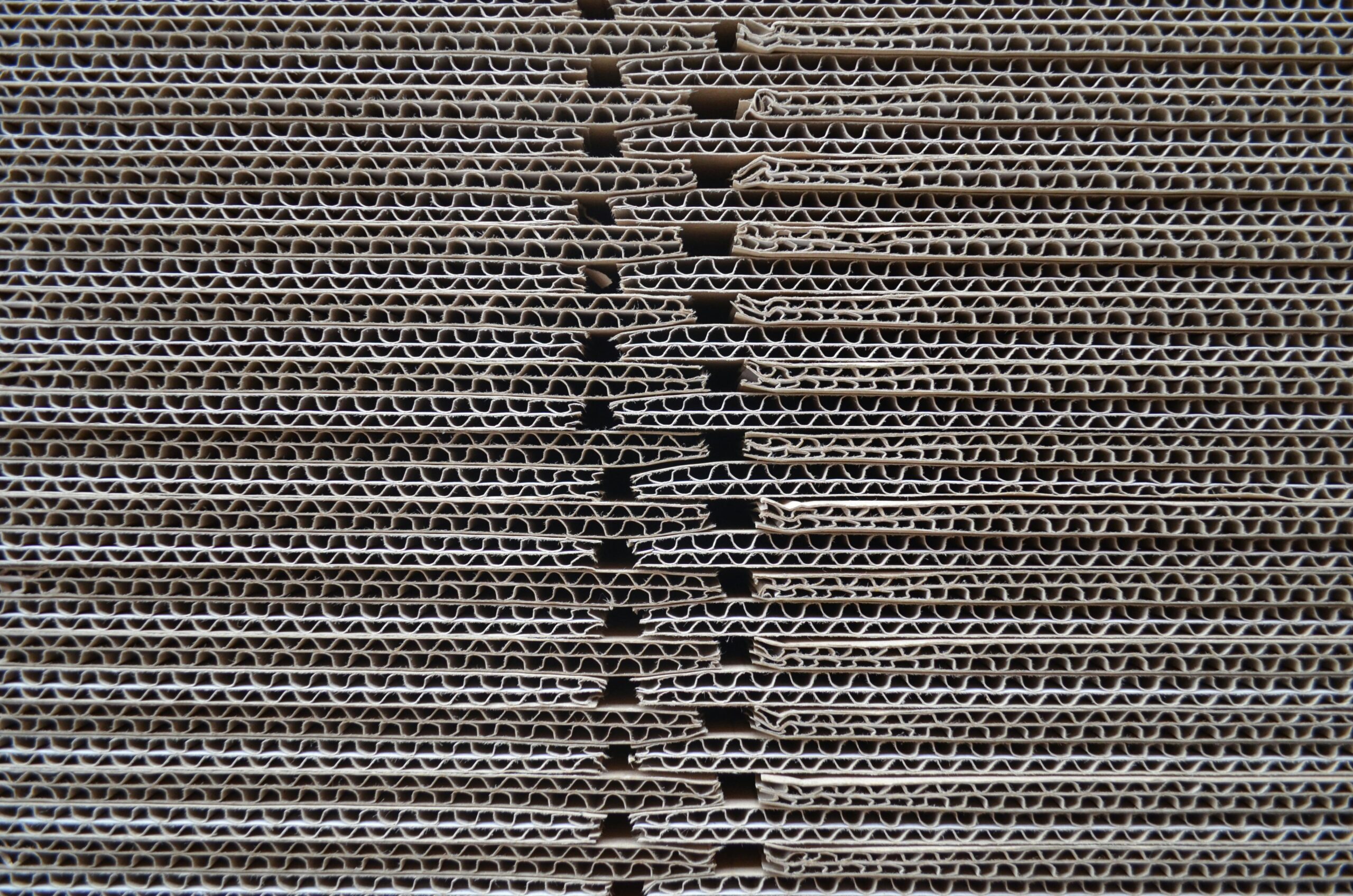 Stacked steel-face sandwich panels in different thicknesses with a tape measure across the pile
