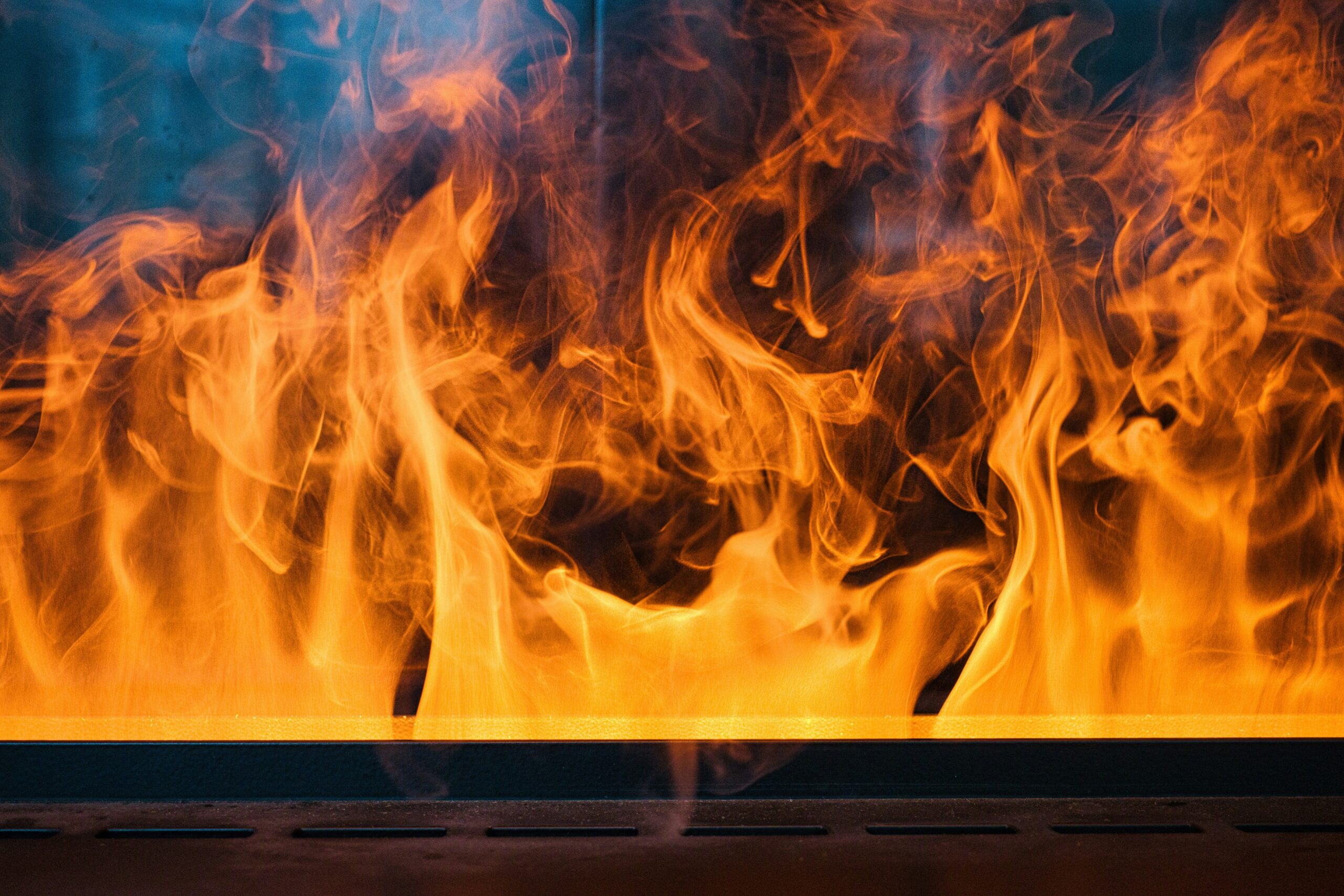 Hyper-realistic photography of a composite sandwich panel undergoing a flame spread test. A controlled flame is applied to the surface of the panel, with clear markings indicating different fire rating classes (e.g., A, B, C) on the panel's surface. The scene is set in a modern, clean laboratory environment. Clean composition, no text, no brand logos.