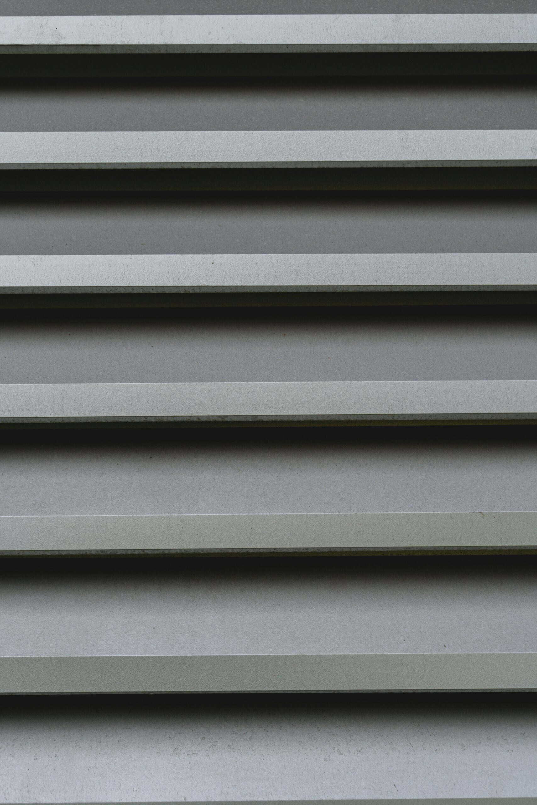 Hyper-realistic photography of a precisely cut IMP (Insulated Metal Panel) sample, possibly with a small, subtle frost or condensation effect on one side, suggesting its application in cold room environments. The panel should appear robust and engineered for thermal control. The background should be a clean, minimalist laboratory or industrial setting. Crisp, cool-toned lighting, clean composition, no text, no brand logos.