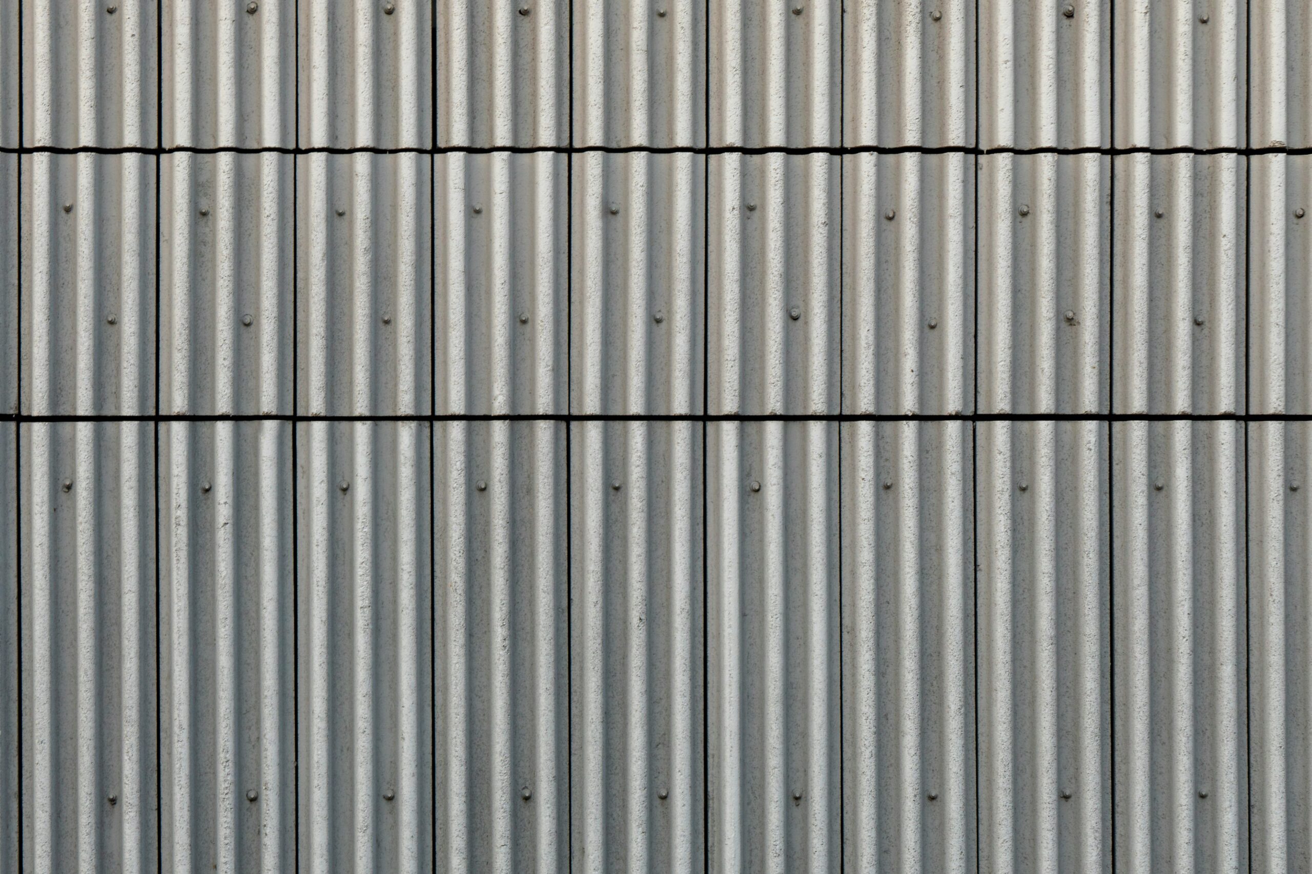 Hyper-realistic photography of the surface of a barn sandwich panel, showcasing different face material options like smooth FRP, textured GRP, and coated aluminum. The surfaces are clean and reflective, emphasizing durability and hygiene. A subtle light source highlights the different textures. Studio lighting, clean composition, no text, no brand logos.
