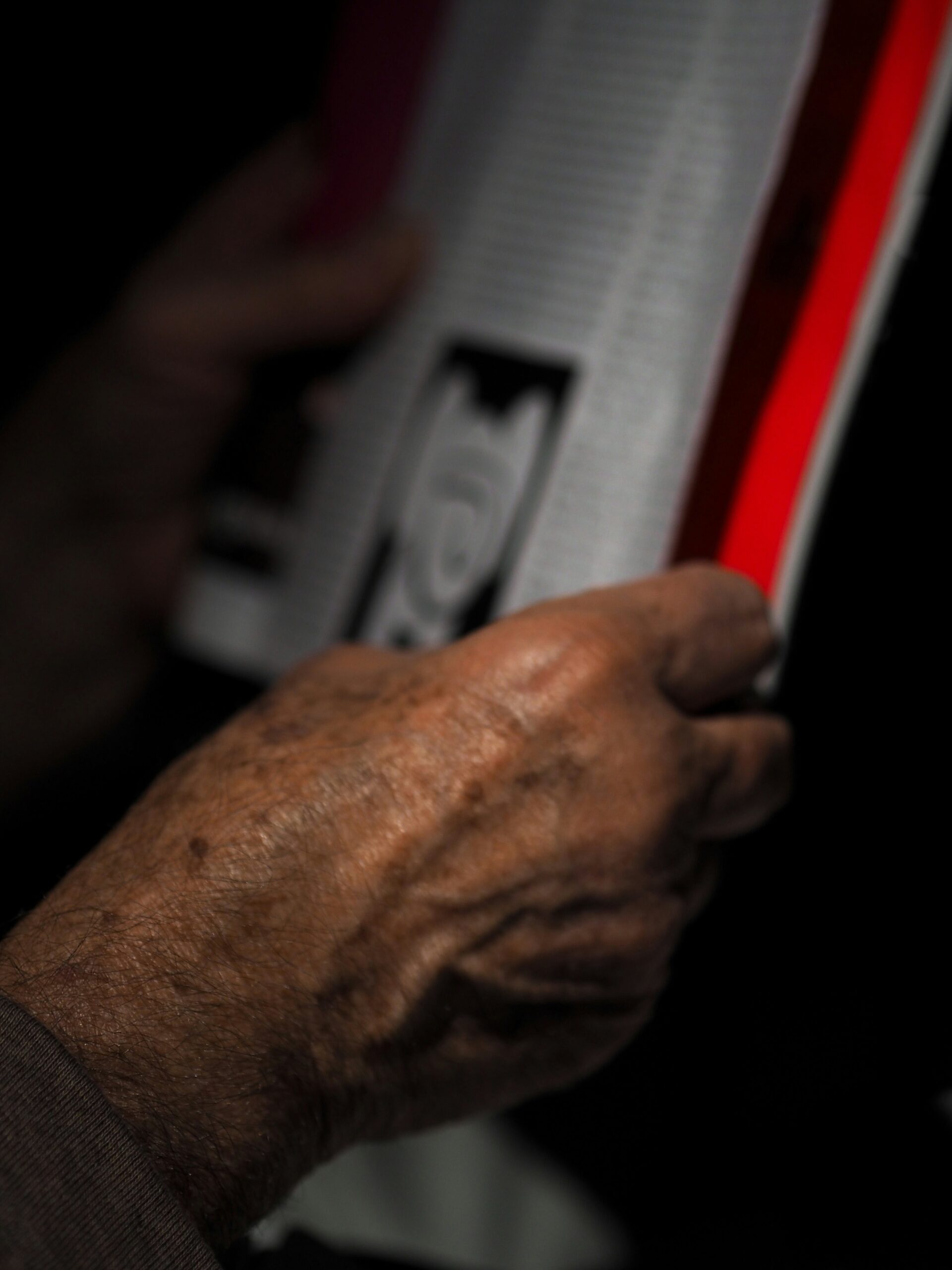 Hyper-realistic product photography of a hand holding a lightweight composite panel made with a foam core, contrasting it with a heavier, traditional material panel. The foam core panel is thin and strong, with a visible cross-section of the core material. The background is a clean, modern industrial setting, well-lit. No text, no brand logos, clean composition.
