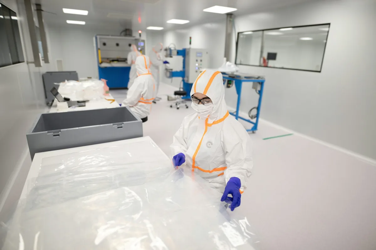 Gowned operators following entry protocol in a clean workshop