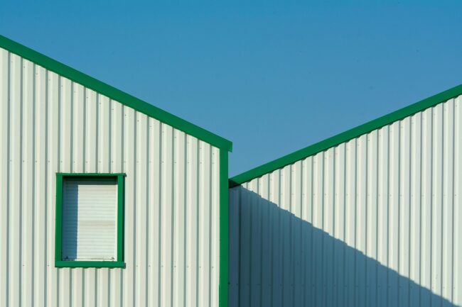 Minimalist building exterior with green accents un Minimalist building exterior with green accents under a clear blue sky.