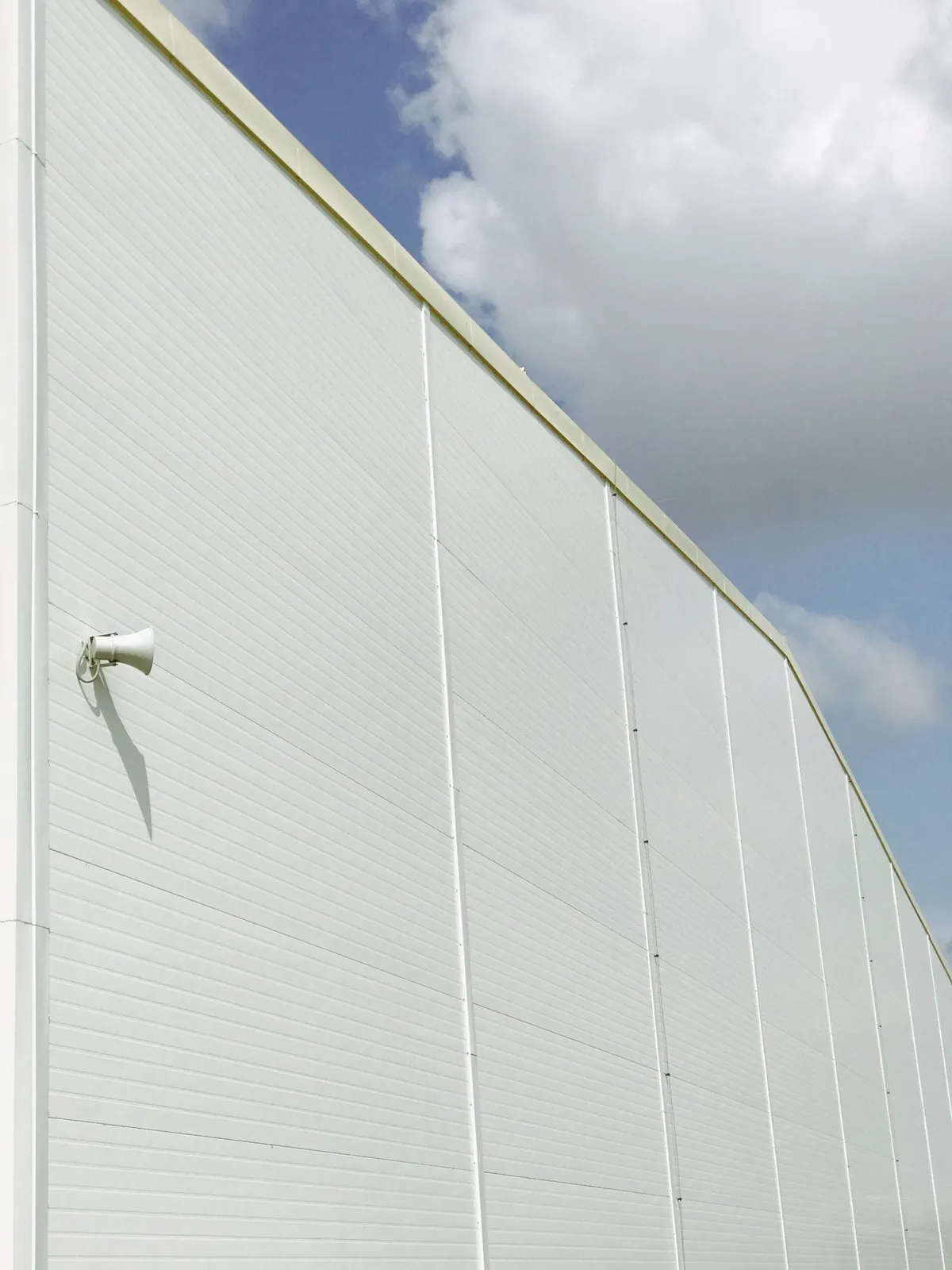 White aluminium panel facade illustrating a clean interior-grade sheet finish