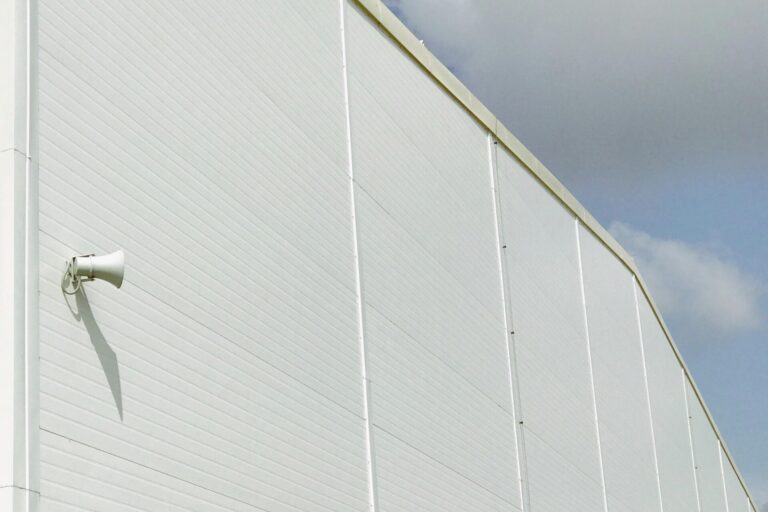 White industrial building facade against a cloudy White industrial building facade against a cloudy sky in Kamianets'-Podil's'kyi, Ukraine.