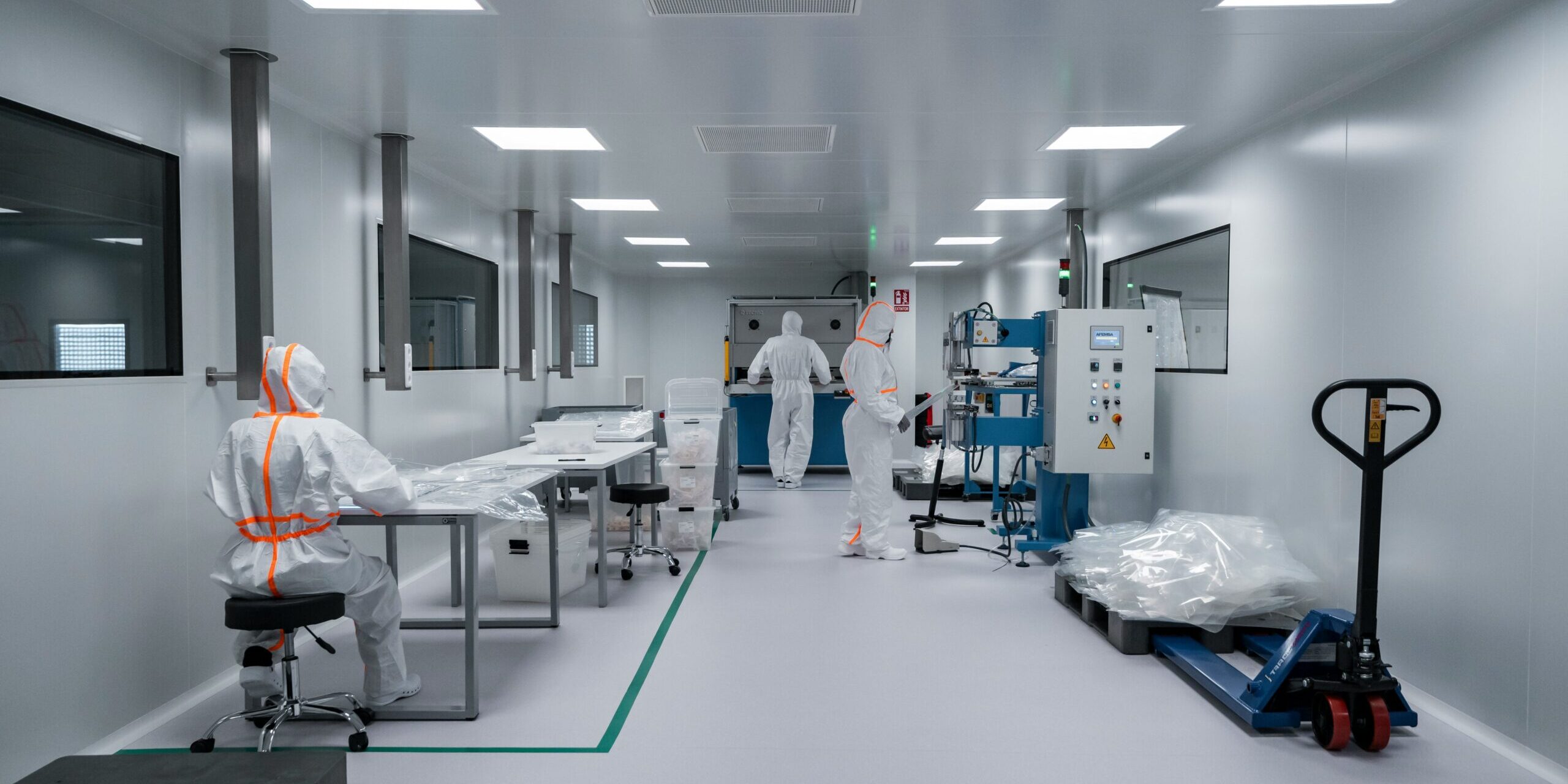 Workers in protective suits inside a sterile labor Workers in protective suits inside a sterile laboratory.